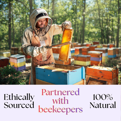 A beekeeper in protective gear inspects a honeycomb frame near colorful hives. Text reads: “Bee Vitality 🐝 — Ethically Sourced, Partnered with Beekeepers, 100% Natural, Enriched with Royal Jelly.”.
